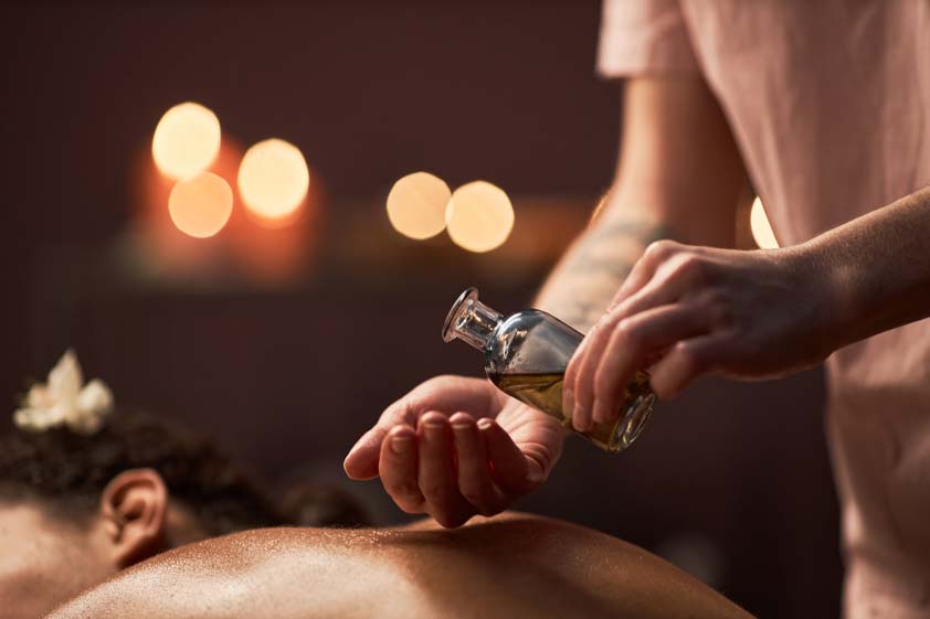 spa therapist applying massage oil